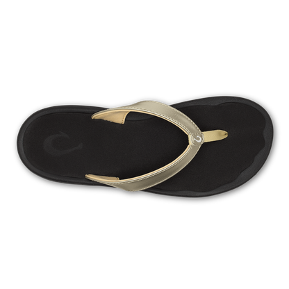 Black flip-flop sandal with gold metallic thong strap and black footbed, top view.