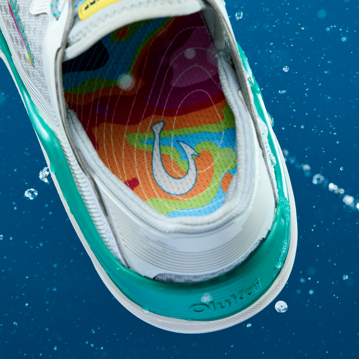 White and turquoise sneaker with colorful rainbow insole featuring a hook design, shown from above.