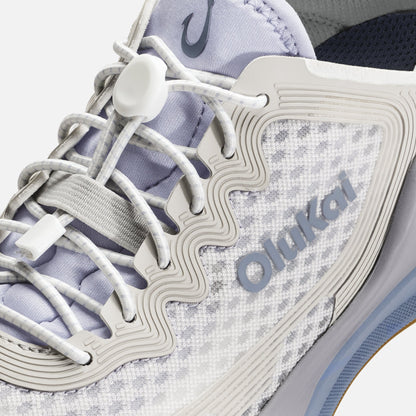 White and lavender sneaker with white laces, "Oma" branding, and textured side panel detail.
